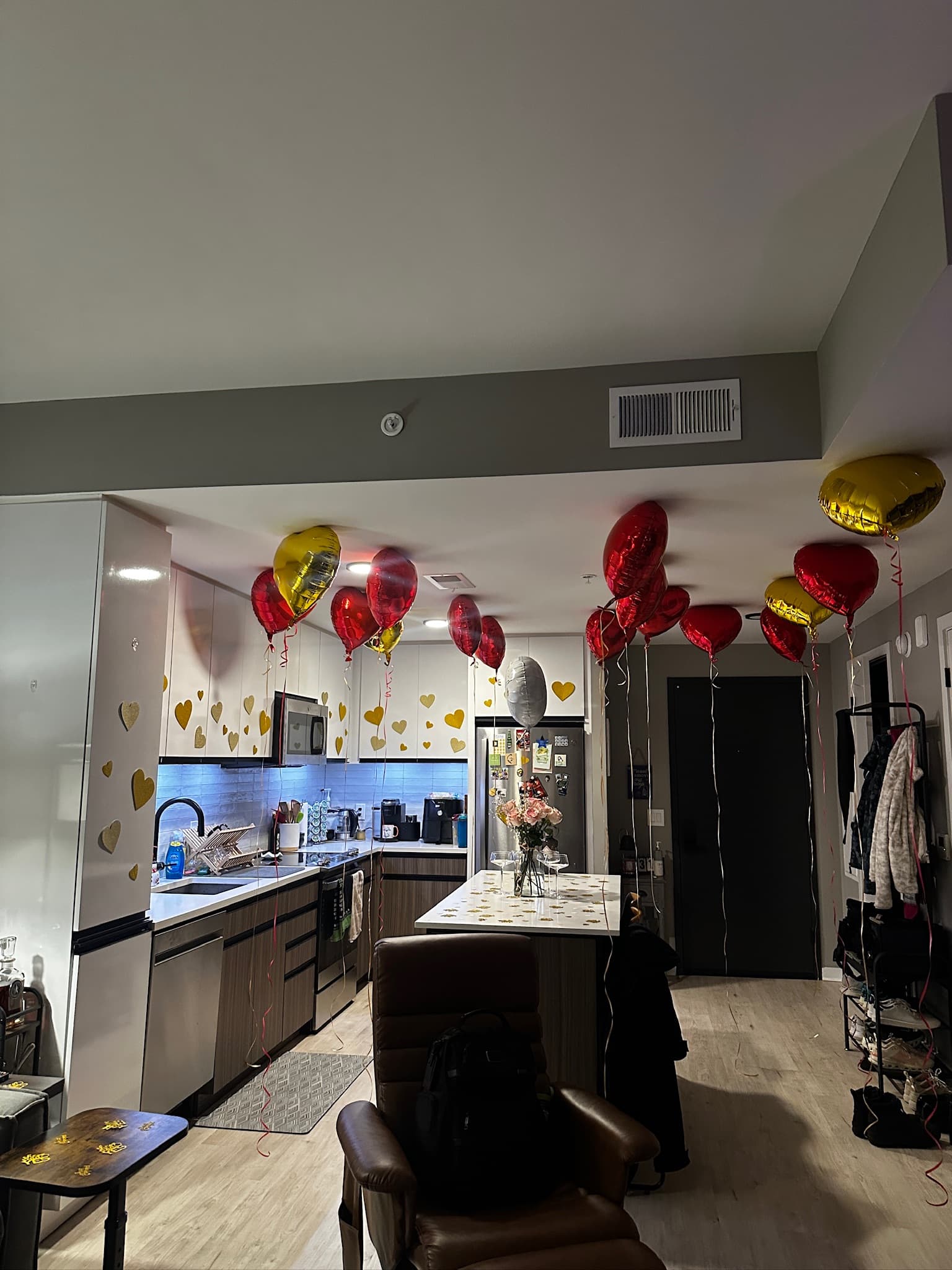 Red and gold heart balloons filling the ceiling with gold confetti