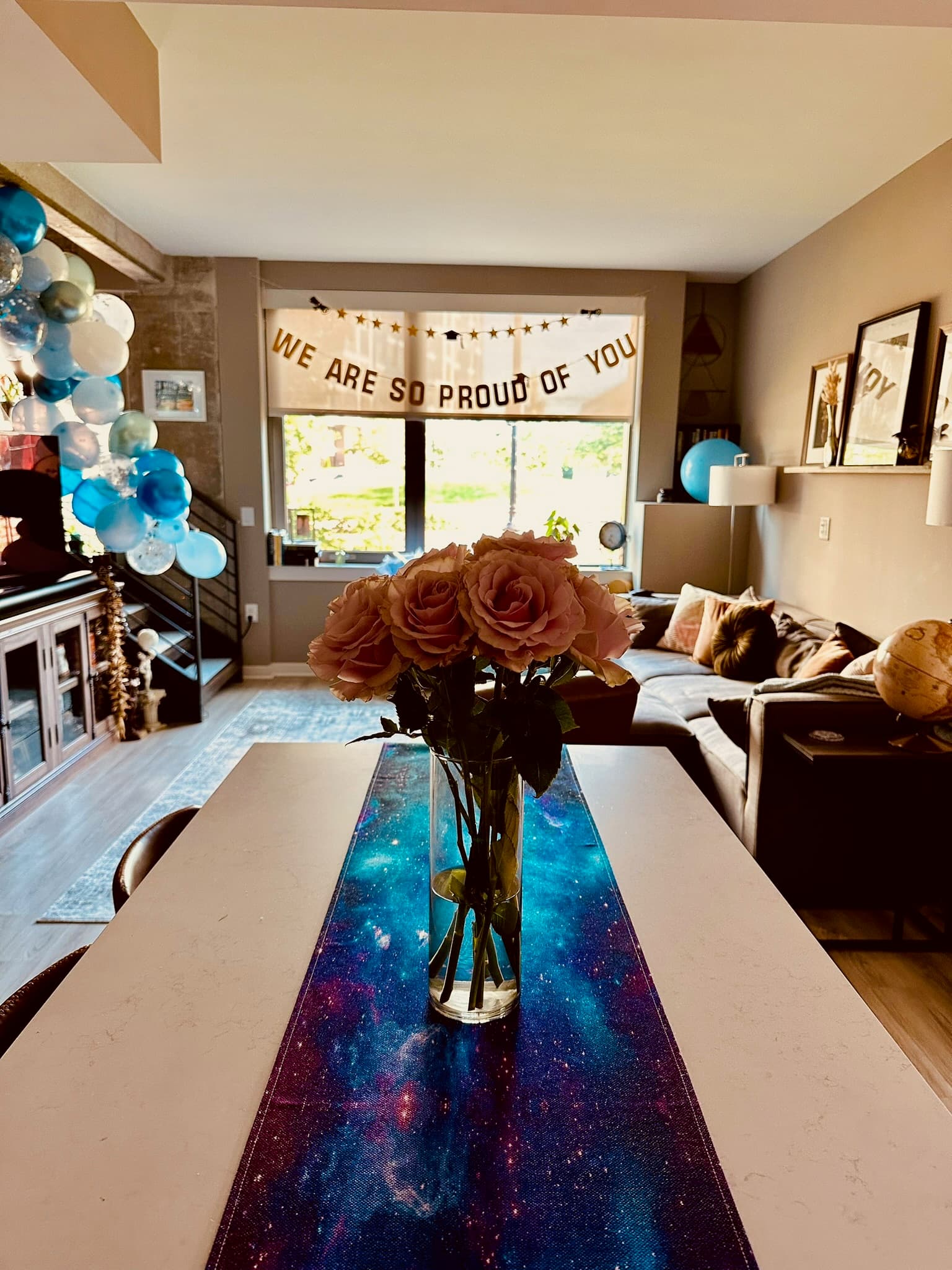 We Are So Proud Of You banner with balloons and roses