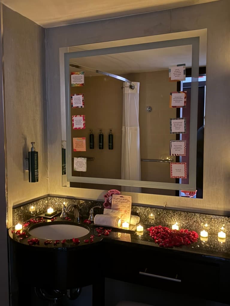 Bathroom counter with rose petals and candles