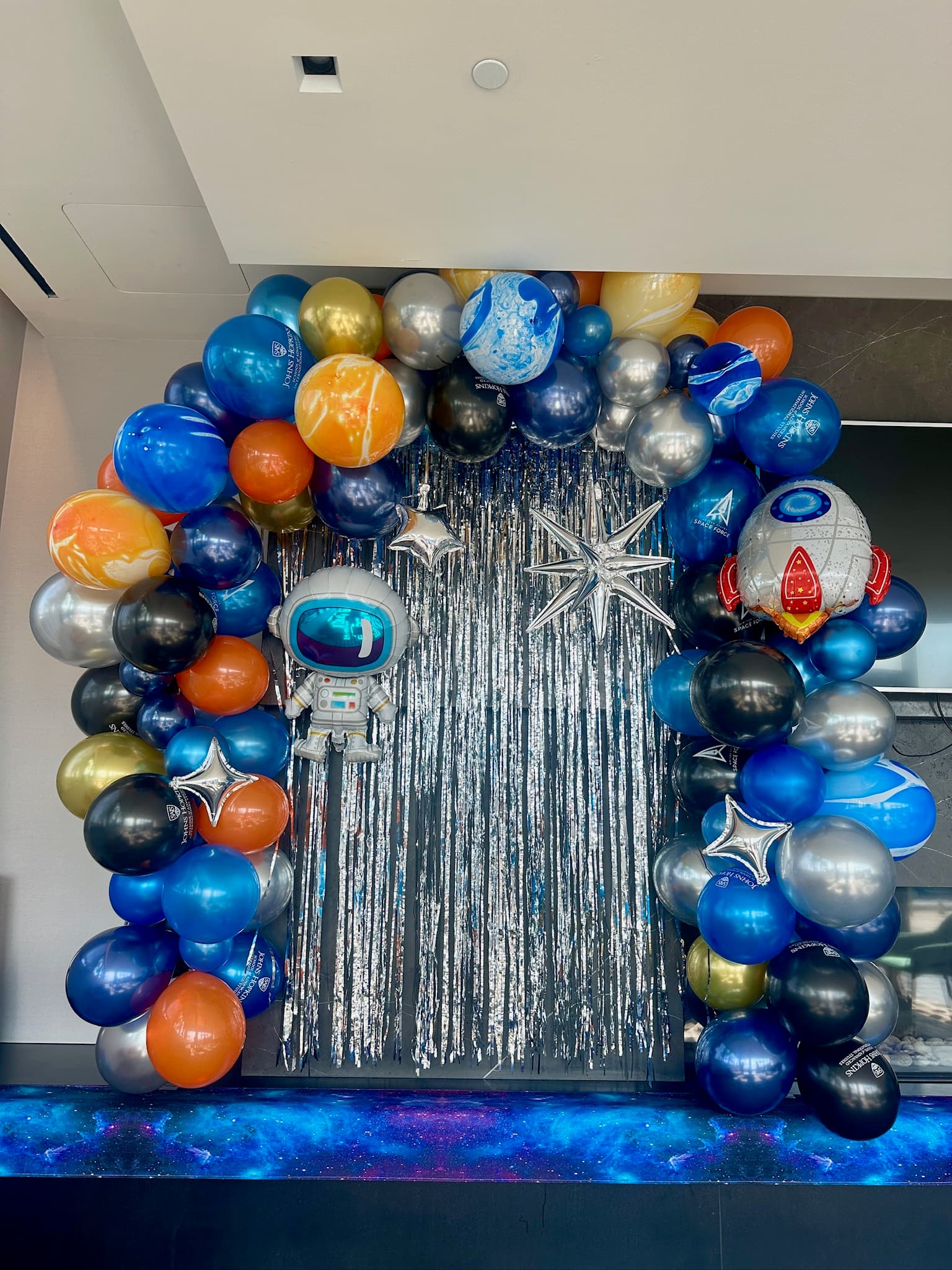 Space-themed balloon arch with astronaut and planets